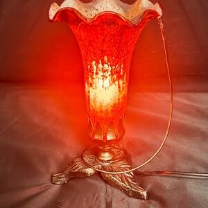 Red mercury glass lily shade lamp with a leaf-motif metal base, made in India.
